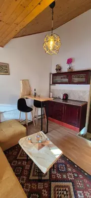 a living room with a table and a kitchen at Apartmani Viktory in Šišava