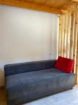 a couch with a red pillow sitting in a room at Villa Paradise in Banja Luka