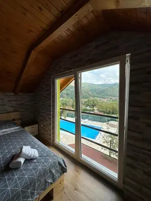 a bedroom with a bed and a large window at Villa Paradise in Banja Luka
