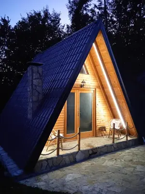 a small wooden cabin with a large window at Vikendica Novska planina in Rudice