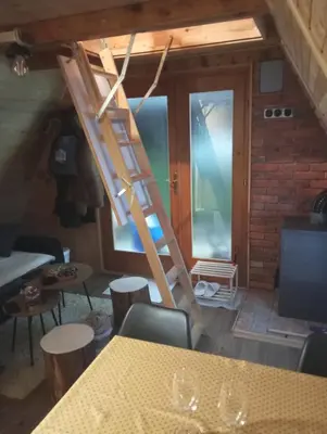 a room with a ladder and a table and chairs at Vikendica Novska planina in Rudice