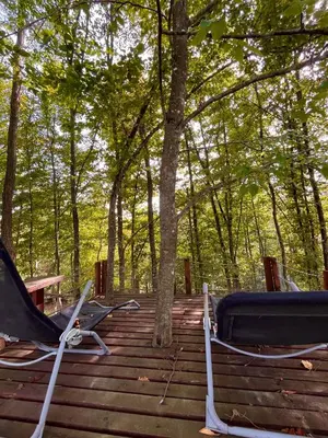 two lounge chairs on a deck in the woods at Vikendica Novska planina in Rudice