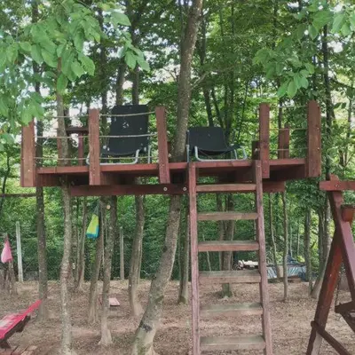 a tree house with chairs in the trees at Vikendica Novska planina in Rudice