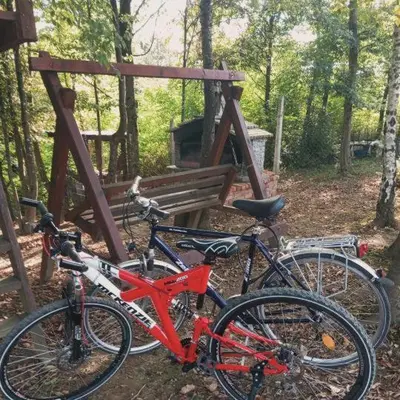 two bikes parked next to a bench in the woods at Vikendica Novska planina in Rudice
