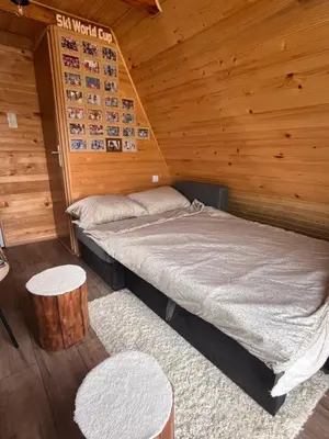 a bedroom with a bed in a wooden cabin at Vikendica Novska planina in Rudice