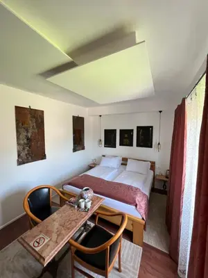a bedroom with a bed and a table and chairs at Soba sa kupaonom i balkonom Aman in Bihać