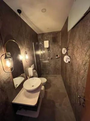 a bathroom with two toilets and a sink and a shower at Soba sa kupaonom i balkonom Aman in Bihać