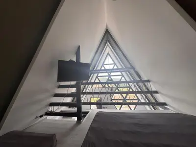 a staircase in a loft with a large window at Ranc 1001 noc in Mutnik
