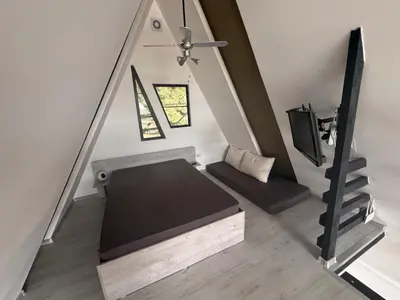 an attic room with a bed and a tv at Ranc 1001 noc in Mutnik