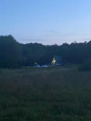 a house in a field with cars in the background at Ranc 1001 noc in Mutnik