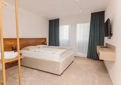 a bedroom with a bed and a mirror at Hotel Marina Home in Prijedor