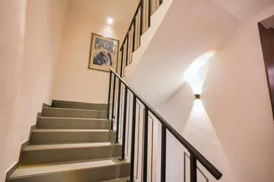 a staircase in a home with white walls and gray stairs at Hotel Marina Home in Prijedor