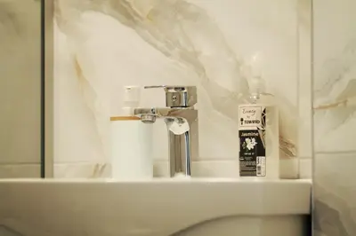 a bathroom sink with a mirror and a bottle of toothpaste at EFESA Apartments in Visoko
