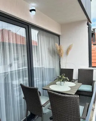 a patio with a table and chairs on a balcony at EFESA Apartments in Visoko
