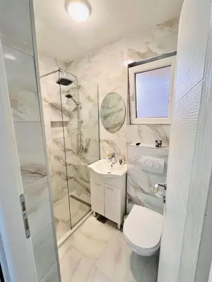 a bathroom with a shower and a toilet and a sink at EFESA Apartments in Visoko