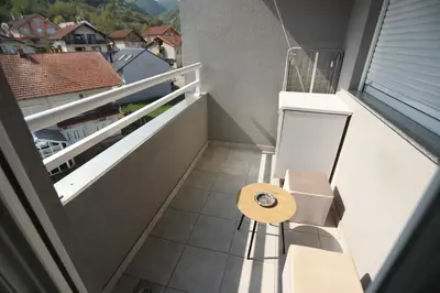 a small balcony with a bench and a table at Apartment - Princ in Banja Luka
