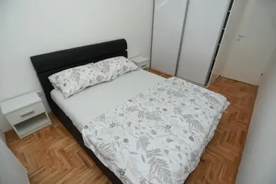 a small bedroom with a bed with a black headboard at Apartment - Princ in Banja Luka