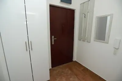 a hallway with a brown door and a mirror at Apartment - Princ in Banja Luka