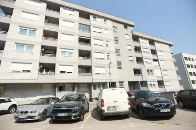 a parking lot with cars parked in front of a building at Apartment - Princ in Banja Luka