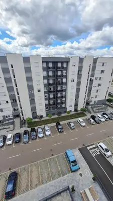 an aerial view of a parking lot with cars in front of buildings at Stan na dan Banjaluka Ada 3 in Rebrovac
