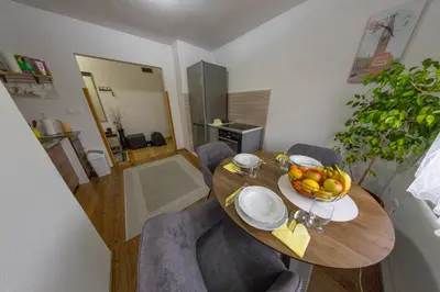 a dining room table with a bowl of fruit on it at Apartman Toromanovic in Bihać