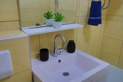 a bathroom sink with two black cups on it at Apartman Toromanovic in Bihać