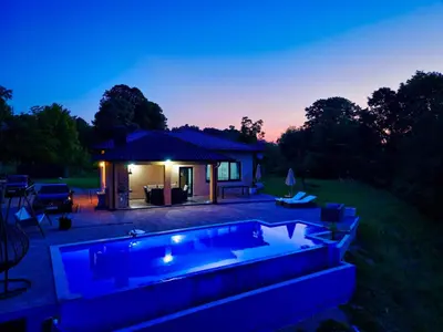 a swimming pool in front of a house at night at Vikendica-Villa Belvedere Srebrenik in Srebrenik