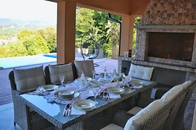 a dining table with plates and napkins on a patio at Vikendica-Villa Belvedere Srebrenik in Srebrenik