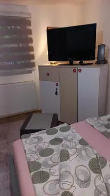 a room with a bed and a tv on a cabinet at Apartman Emina in Visoko