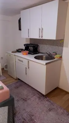 a kitchen with white cabinets and a sink at Apartman Emina in Visoko
