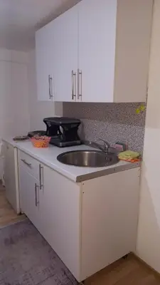a kitchen with a sink and white cabinets at Apartman Emina in Visoko