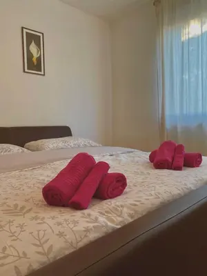 three red towels on a bed in a bedroom at Apartman M&M Livno in Livno
