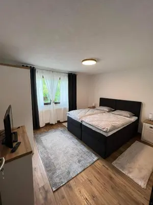 a bedroom with a large bed and a window at Apartman City Bihać in Bihać