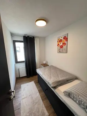 a small bedroom with a bed and a window at Apartman City Bihać in Bihać