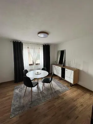 a living room with a table and chairs and a television at Apartman City Bihać in Bihać