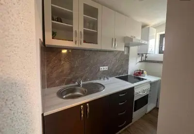 a kitchen with a sink and a stove at Apartman City Bihać in Bihać