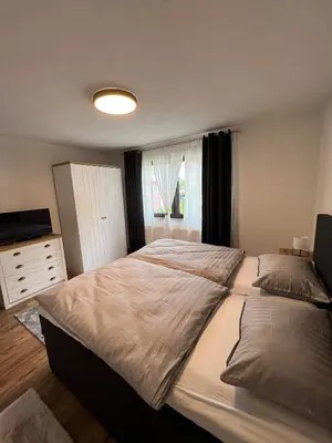 a bedroom with a large bed and a window at Apartman City Bihać in Bihać