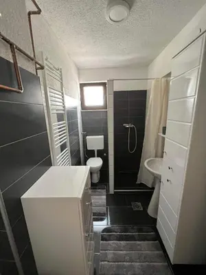 a bathroom with a white sink and a toilet at Apartman City Bihać in Bihać