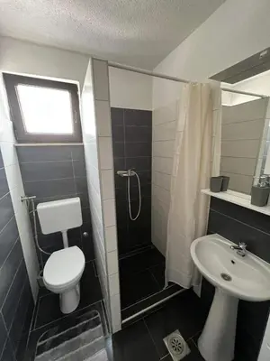 a bathroom with a toilet and a shower and a sink at Apartman City Bihać in Bihać