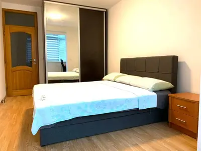 a bedroom with a large bed and a mirror at Apartman H&A in Tuzla