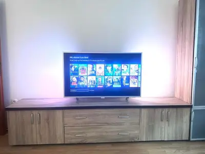 a flat screen tv sitting on top of a wooden entertainment center at Apartman H&A in Tuzla