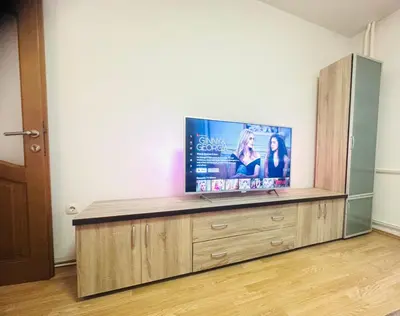 a flat screen tv sitting on top of a wooden entertainment center at Apartman H&A in Tuzla