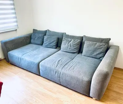 a blue couch sitting in a living room at Apartman H&A in Tuzla