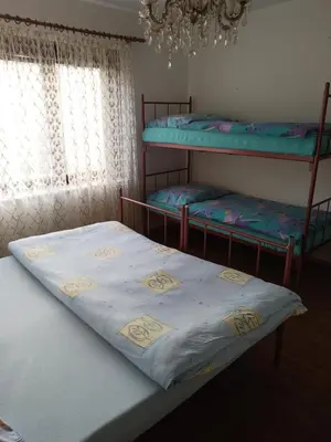 a bedroom with two bunk beds and a chandelier at apartman SM IK 2 in Šujica