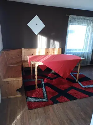 a table with a red umbrella on top of a rug at apartman SM IK 2 in Šujica