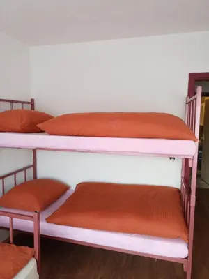 three bunk beds in a room with orange pillows at apartman SM IK 2 in Šujica