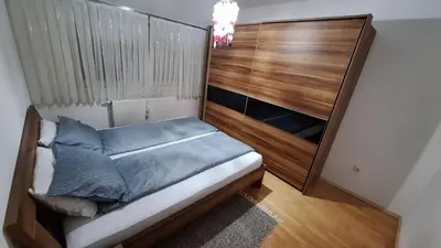 a bedroom with a bed with a wooden headboard at Srce Cazina in Cazin