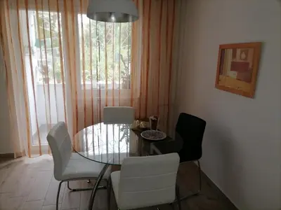a dining room with a glass table and white chairs at Apartman iza Boske in Banja Luka