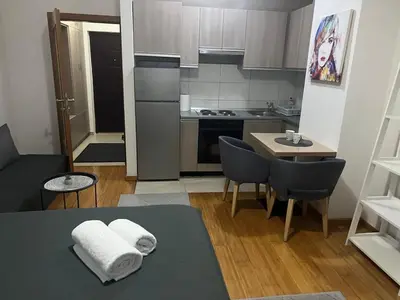 a small kitchen with a table and chairs in a room at Studio apartman MyPLACE in Bihać