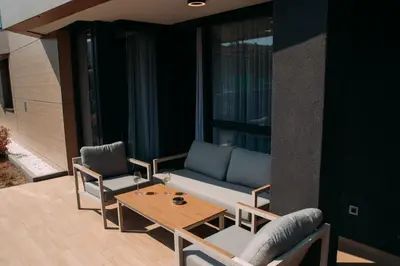 a patio with a couch and two chairs and a table at LuxDS in Tuzla